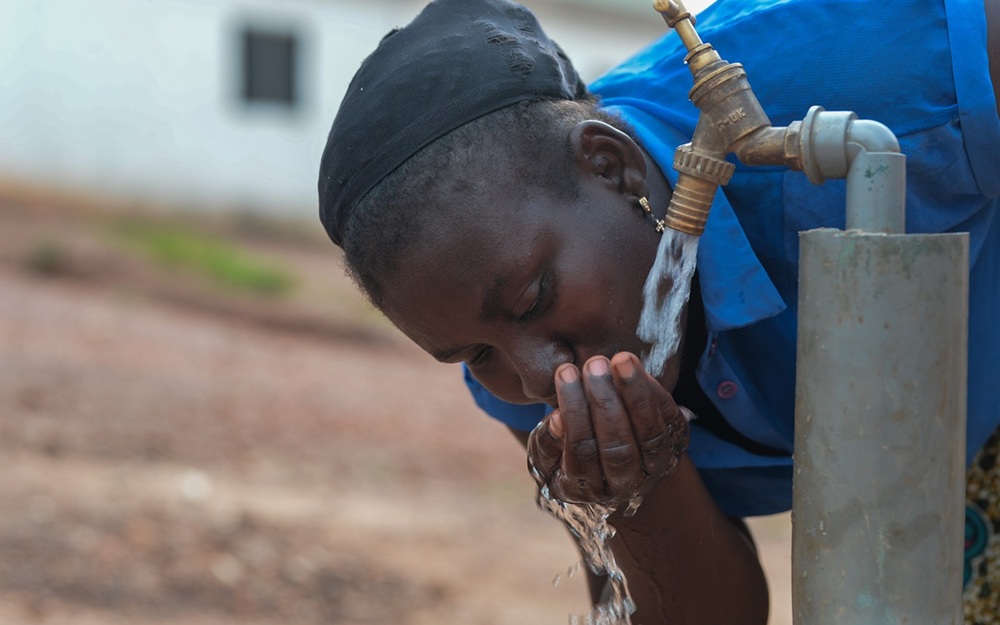 Girl in blue dress drinking water Girl in blue dress drinking water